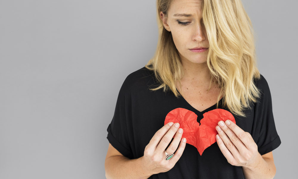 Mulher triste segura coração partido